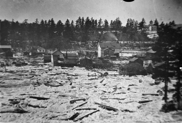 Copy photograph of an ice jam on a river and a town.