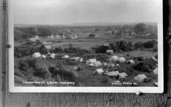 Copy photograph of an outdoor view of a Crow Indian Encampment. Credited to O'Neill Photo Co.