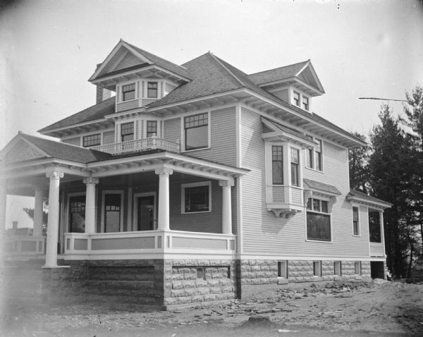 View from lawn of a two-story wooden house with a stone foundation, which appears to be newly built. The house is identified as the residence of F. Keefe, who bought the house before its completion from Klofauda (?) in 1909, located at the southeast corner of Third and Madison Streets.