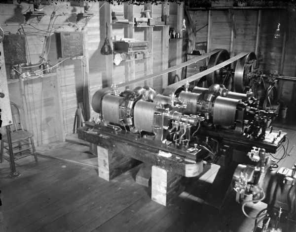 View looking down at machinery inside a building. Identified as the interior of a powerhouse, showing the generator.