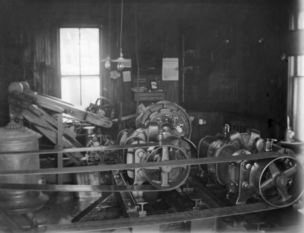 Indoor view of machinery inside a building. Identified as the interior of a powerhouse, showing the generator.