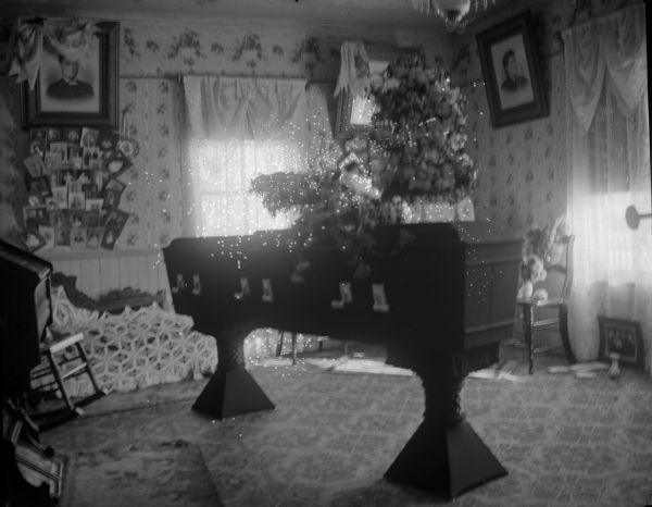 Indoor view of a flower-draped casket in a room with walls covered with photographs.