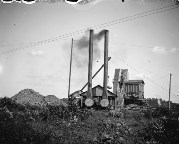 View of machinery at a dam construction site. Identified as the rock crusher at the construction of the Hatfield dam.