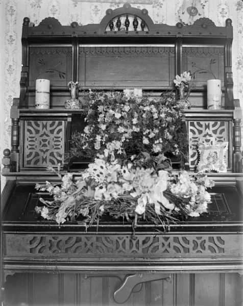 View of a floral arrangement sitting on an organ.