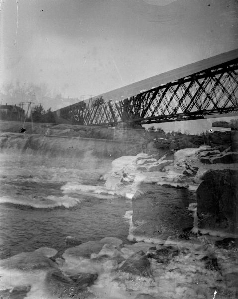 Double exposure, with the main view towards a railroad bridge across a river; the other view is of a dam.