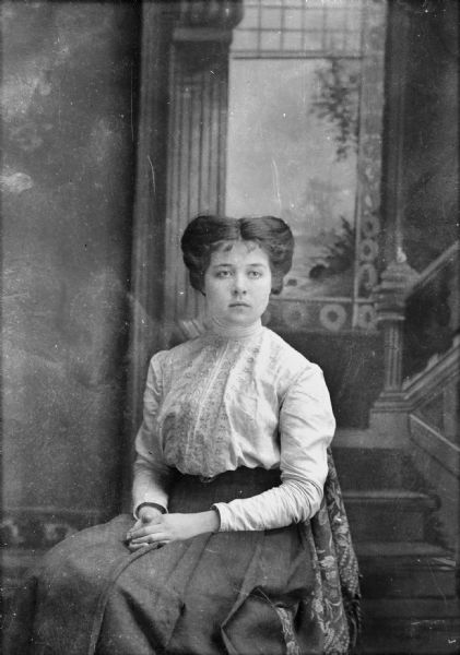 Studio portrait of a European American woman posing sitting.