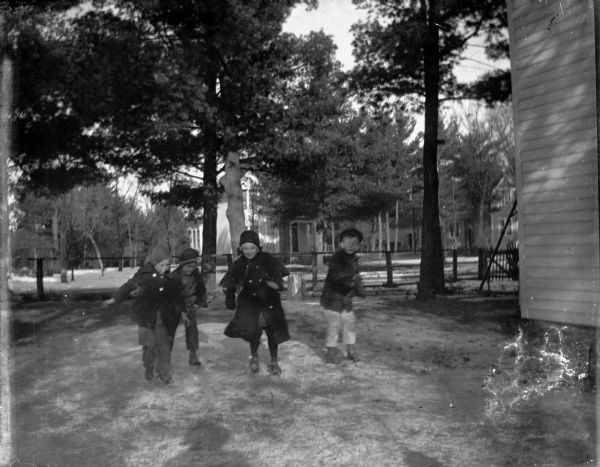 Outdoor view of four children playing in a yard.