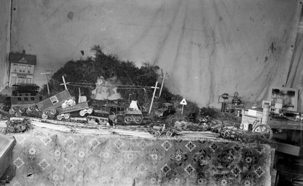 Interior view of a model train on a table arranged to simulate a train wreck.