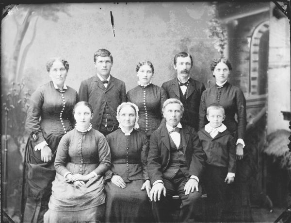 Studio group portrait of a family, including three men, five women, and a boy.
