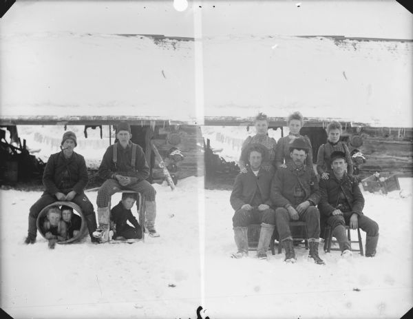 Left side: Group portrait of two men posing sitting on a box and barrel. Two boys are posing inside the barrel, and one boy is posing inside the box. Right side: Group portrait of three men posing sitting in front of three women posing standing.