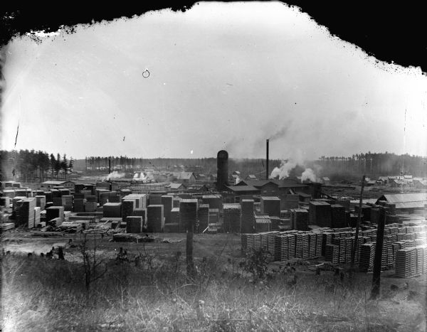View from hill of the McKenna Sawmill, surrounded by stacks of lumber.
