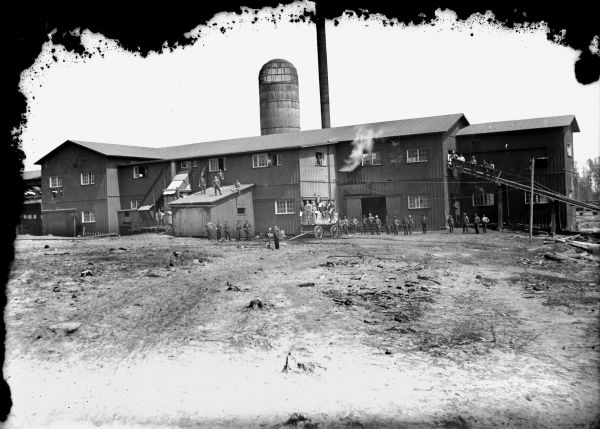 View of the McKenna Sawmill. Workers are posing in front.
