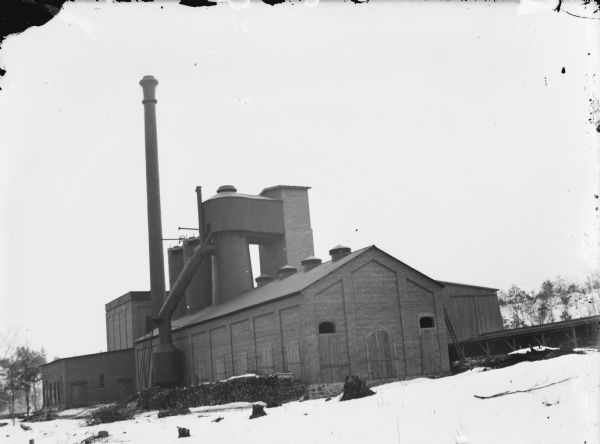 View of the York Iron Mine in winter. Stacks of wood are along the left side of the building.