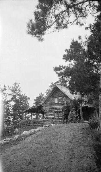 Two men pose alongside the Hotz Cottage at Europe Lake.  The man in the background is David Kincaid, the caretaker.
