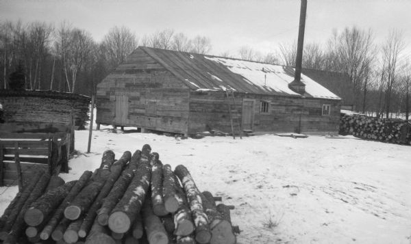 The sawmill at Newport in winter, with logs and lumber stacked nearby.