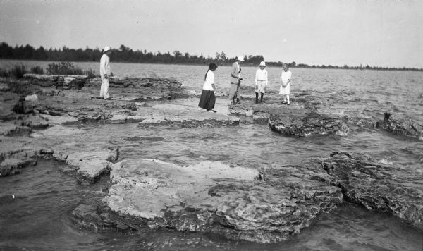 Thomas Toft, left, on the rocky shore of Moonlight Bay with the photographer's children, from left, Helen, Alice, Ferdinand Leonard, and Margaret. Alice holds a small camera.