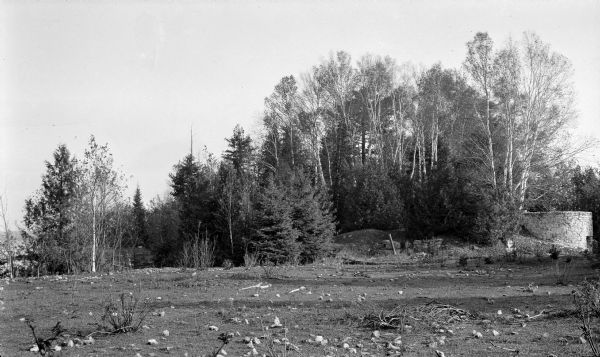 The lime kiln, at right, at Toft Point. Crushed limestone from the nearby quarry was heated in the kiln to make whitewash. Evergreen trees and birches form the background.