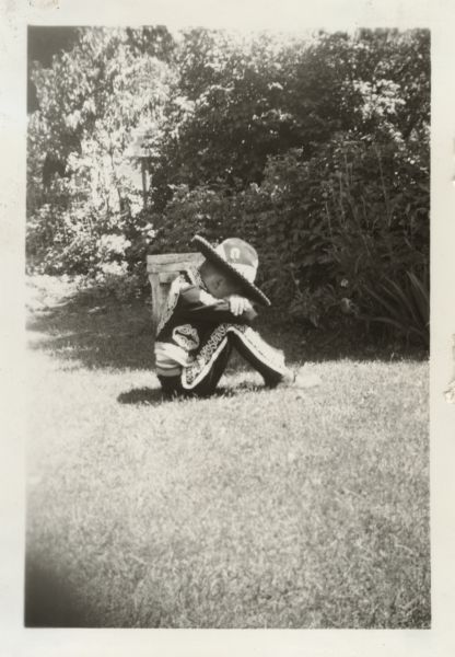 Robert E. Faber (b. 1933) posing seated in his backyard as if taking a siesta.  He is wearing a Mexican cowboy costume purchased by his parents Michael and Margaret (Diebold) Faber when they vacationed in Mexico City, Mexico during January 1938.

Robert's home was located in the 2500 block of Van Hise Avenue, Madison, Wisconsin.

