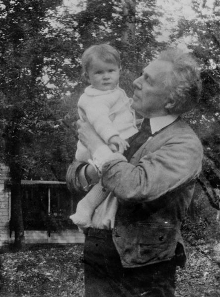 Frank Lloyd Wright holds his baby daughter, Iovanna, in an outdoor informal portrait. She is looking at the camera and he is gazing at her. Iovanna Lazovich Lloyd Wright was born on December 2, 1925. Her mother was Wright's third wife, Olgivanna.