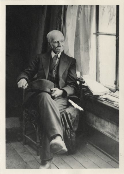 Informal portrait of Charles J. Van Schaick sitting by the window in his gallery, taken by his son Roy Van Schaick.