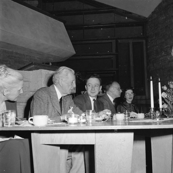 The head table at a dinner marking the 75th anniversary of the First Unitarian Society of Madison. Seated at the table are Frank Lloyd Wright and, next to him, minister Max Gaebler. Wright, who designed the Unitarian Meeting House, was the son of one of the society's founders.