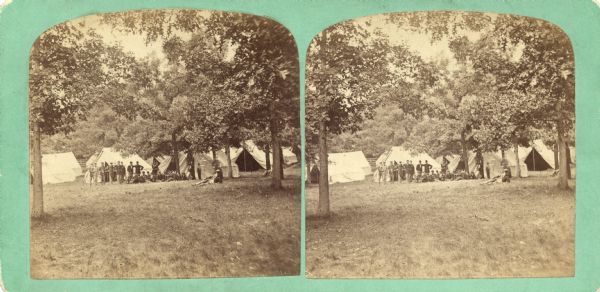 Stereograph, probably one of Dahl's images from "Centennial Views of Madison, July 4th, 1876." In the distance, a group of soldiers stand in front of a tent in a camp.