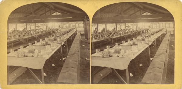 Quite possibly this is the "View of the Dining Tent" listed in the "Centennial Views of the City of Madison, July 4th, 1876. Views of Chicago Light Guard" section of Dahl's 1877 "Catalogue of Stereoscopic Views." The men were encamped at Camp Randall or on the shores of Lake Monona.