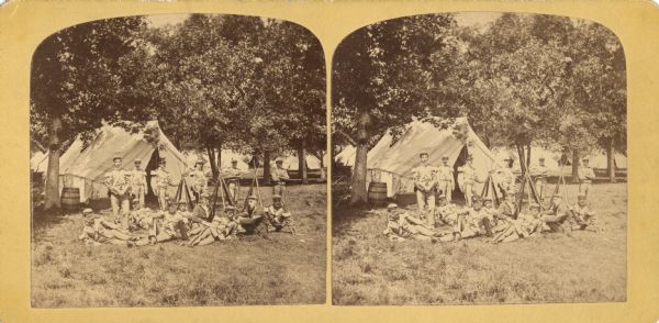 Quite possibly this is the "View of Guard Tent and Guard" listed in the "Centennial Views of the City of Madison, July 4th, 1876. Views of Chicago Light Guard" section of Dahl's 1877 "Catalogue of Stereoscopic Views."<p>Company of fourteen men at ease in front of tent. Rifles stacked, all men in uniform.