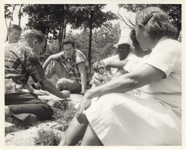 Seated group observes Myles Horton making notes.