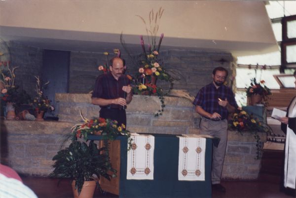 Holy Union ceremony of Brian Bigler (left) and Ken Scott (right) on July 22, 1995 at the First Unitarian Church, Madison, Wisconsin.  Taken during the candle lighting portion of the ceremony at the altar. The altar cloths were made by a Ukrainian friend. This may have been one of the first such unions in Madison.