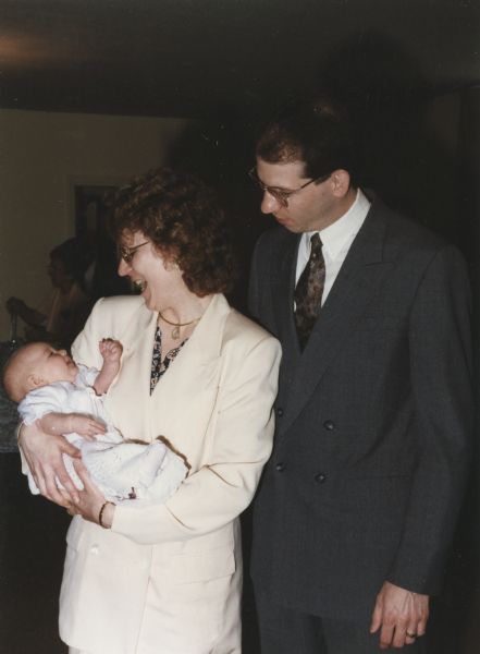 Jessica Mary Bertenshaw being held by her godmother Jill (Howman) Bremigan at her baptism on May 12, 1996 at Brentwood Congregational Church in Brentwood, Missouri.  Jill is standing next to her husband Cary Bremigan, who was a high school friend of Jessica's father Steve Bertenshaw and godfather to Jessica.  The Bremigans are Madison, Wisconsin residents.