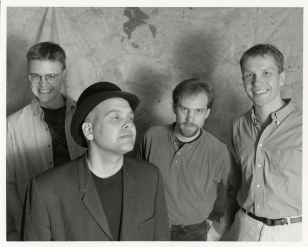 Publicity photograph of the four band members of Marques Bovre & the Evil Twins, a Madison, Wisconsin band. From left to right are Eric Dummer, Marques Bovre, Doug Meisner, and Linus.