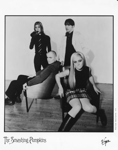 Publicity photograph of the four band members of The Smashing Pumpkins, a Chicago, Illinois rock band. From left to right are James Iha, Billy Corgan (seated), Jimmy Chamberlain, and D'arcy Wretzky (seated).<p>Virgin (Records) is mentioned on the photograph.