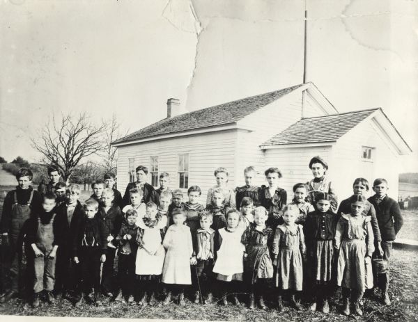 Rural school group posed outside the schoolhouse.