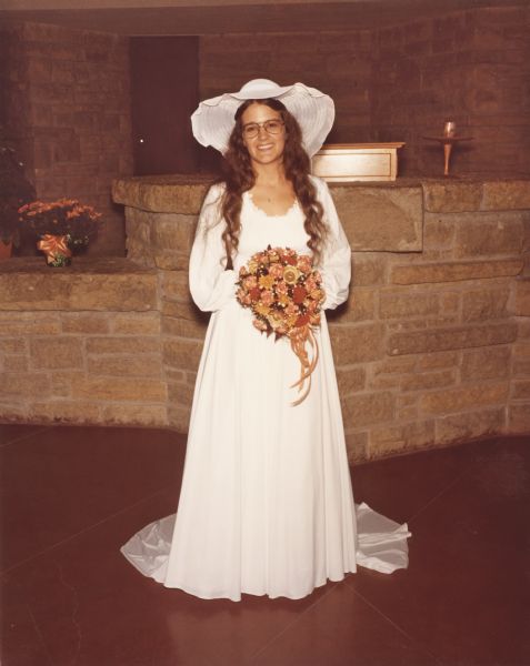 Full-length portrait of a bride at the First Unitarian Society Meeting House after the ceremony.