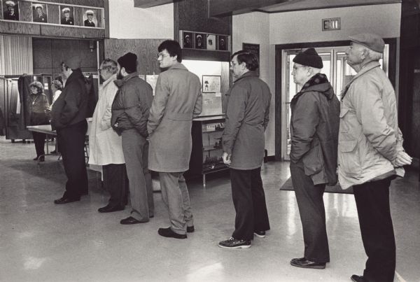 Seven men wait for the polls to open Tuesday morning at the New Berlin Administration Building.