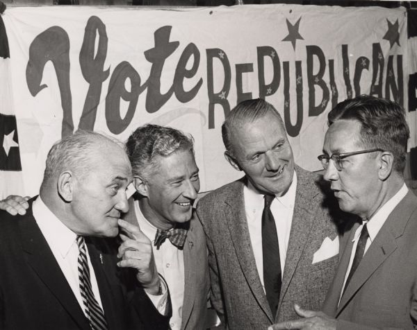Four men have a conversation in front of a banner that reads, "Vote Republican." The second man from the left is Warren P. Knowles, Lt. Governor.