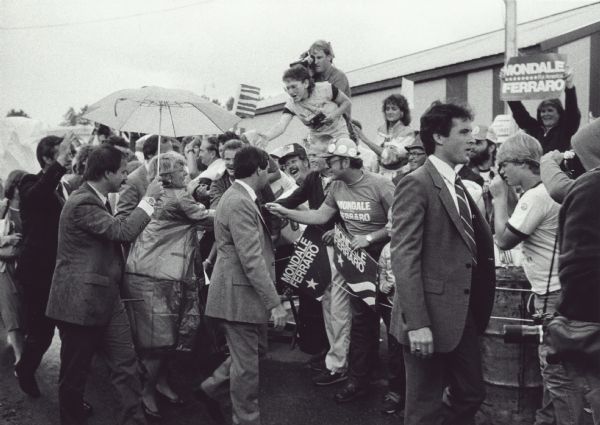 Democratic vice-presidential candidate Geraldine Ferraro greets supporters while campaigning. A little rain failed to dampen their enthusiasm for the first woman nominated to that position by a major party.