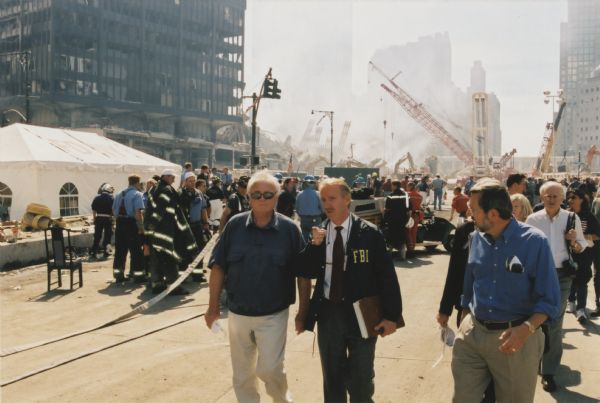 Wisconsin Congressman David R. Obey (right) and Florida Congressman Young tour the destruction at the World Trade Center with an FBI guide a few days after 9/11. Behind Obey, to his left, is his legislative assistant Scott Lilly. Young and Obey toured the scene as Republican and Democratic heads of the House Appropriations Committee which appropriated the emergency funds for the aftermath to 9/11. In the background is 6 WTC which housed the US Customs Office.