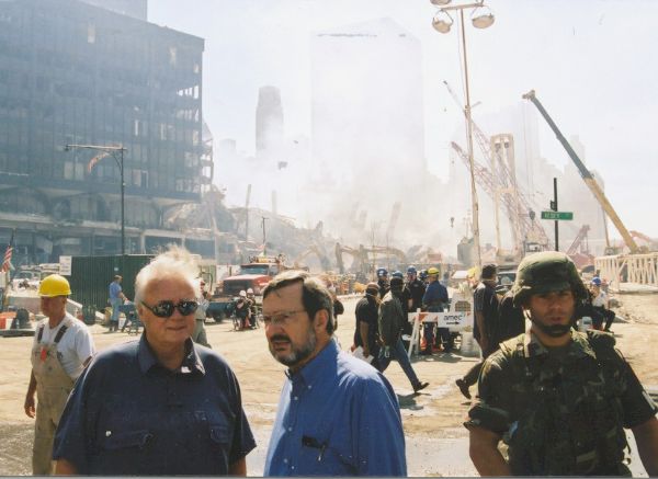 Florida Congressman Bill Young (left) and Wisconsin Congressman David R. Obey at the intersection of Vesey Street and the West Side Highway, ground zero for the 9/11 attack on the World Trade Center. As, respectively, the Republican chair and ranking Democratic, they were at the site to see the damage first-hand. Behind them are the ruins of World Trade Center Building 6 (WTC6) and the debris pile of the North Tower. The National Guard soldier is unidentified.