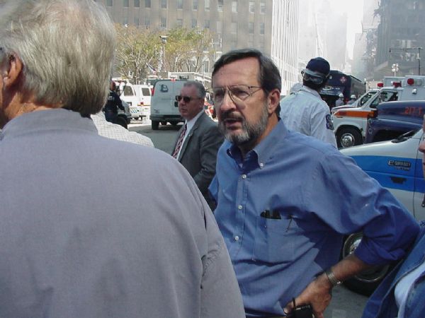 Wisconsin Congressman David R. Obey (in blue shirt) standing at the intersection of Vesey Street and the West Side Highway near the World Trade Center site. In the background to Obey's right is World Trade Center Building 6, which was damaged during the collapse of the twin towers, and to his left, the Verizon Building, which experienced major damage. Obey was at the site because of his position as ranking Democrat on the House Appropriations Committee, the committee for authorizing emergency federal funding.