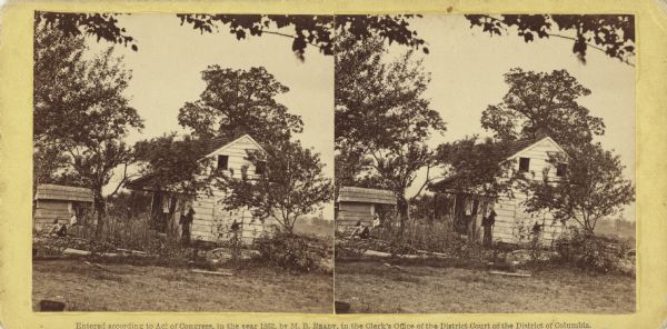 Stereograph of the farmhouse of Abram Bryant, a free black man who lived near Gettysburg, Pennsylvania. An African American man is standing near the porch and another man is sitting on the left with his hat on the ground. This card was purchased at Brady's studio by Lucius Fairchild probably in October 1863. Fairchild, who had commanded the 2nd Wisconsin at Gettysburg, wrote on the stereograph that it was General Meade's headquarters, an error he must have learned from Brady who mistakenly identified this image in later editions of his Gettysburg work. It was a logical mistake. Bryant's house was located about 100 yards from Meade's headquarters which was also a white farmhouse.