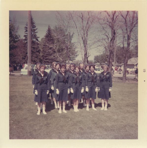 Patricia Mullins (3rd from right) and her Mariner Scout Troop pose outdoors.
