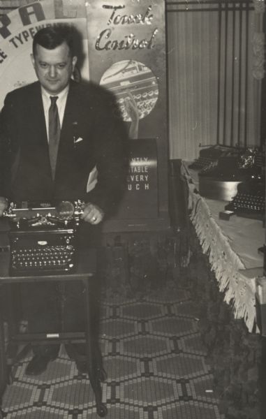Stanley Stemp (owner) standing behind a typewriter in the Stemp Typewriter Company located at 533 State Street. This store was referred to as the "Little Store" by the owner and his staff.