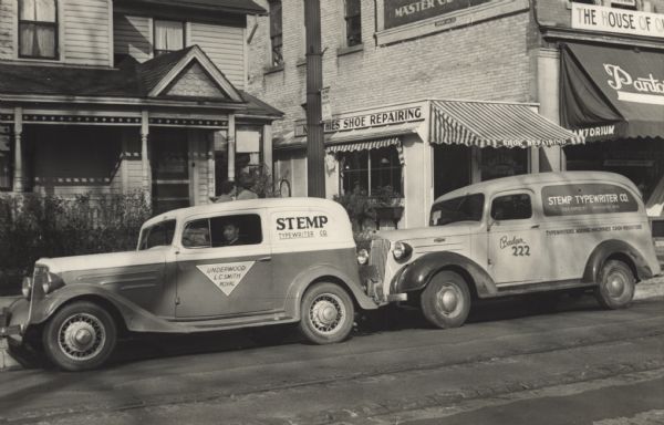 The Stemp Typewriter Company's two red and white service trucks. The company picked up and then delivered typewriters in need of repair. They also delivered new typewriters. Service to the customers was the most important thing. T.H. Achworth, salesman, can be see in the first truck.