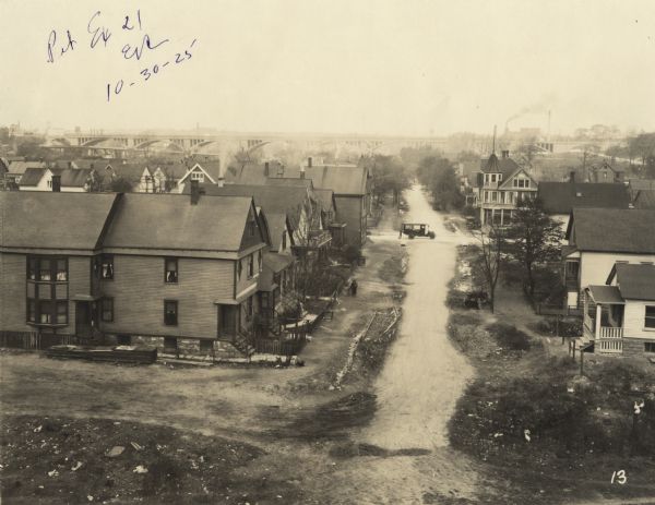 Elevated view of street through a neighborhood from a railroad embankment. A truck and driver can be seen in the intersection. An elevated bridge is just visible in the background. Text at foot of photograph reads, "39th St. 17+45 Looking North from Line." Handwritten in ink at top, "Ex. 21, ER, 10-30-25."