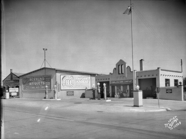 Conklin and Sons oil station at 655 W. Washington Avenue. A billboard on the side of building says "Sinclair HC Gasoline Stops Knocks." Next door on the left is the A. Sinaiko, Hay, Flour and Feed building, 653 W. Washington Avenue.