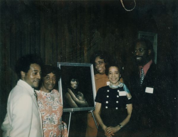Group portrait at the Mary Church Terrell Creative Center, which was founded in 1963 by Bernice Lindsay (second from left). The Creative Center was located at 3705 N. Teutonia Avenue and was one of five arts programs administrated by the Inner City Arts Council. Ms. Lindsay is standing next to Lee Fields, a soul musician. They are standing next to a painting. To the right of the painting is Vel Phillips, who was a member of the Milwaukee County judiciary at that time. Behind her is an unidentified woman. To her right is Daniel Burrell, who had been a community organizer and was then director of the Center for Afro American Culture at UW-Milwaukee.