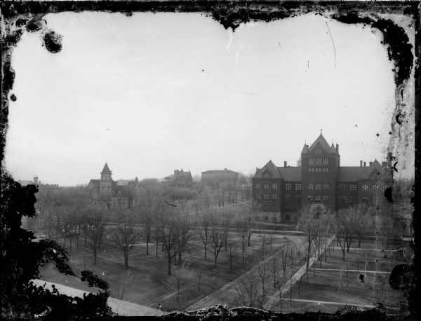 Elevated view along Langdon Street towards Science Hall on Bascom Hill at the University of Wisconsin-Madison. On the opposite side of Bascom Hill is Music Hall, the old Law Building, and South Hall. In the foreground on the left, which has paths on the lawn through the trees, is the future site of the State Historical Society of Wisconsin (Wisconsin Historical Society). State Street runs into Park Street which runs along the base of Bascom Hill.