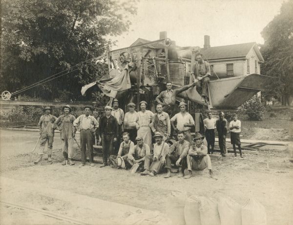 The "O'Dea and Shafer, Engineers and Contractors" construction crew, posing with a piece of equipment. A house and trees are in the background. Bags of cement are stacked in the lower right corner.
